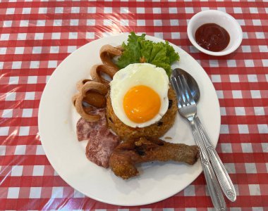Jambonlu pilav, sosis ve kızarmış tavuk, üstüne de yumurta.