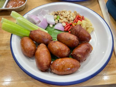 Tayland usulü ızgara sosis, salatalık, dilimlenmiş kırmızı soğan, acı biber ve kavrulmuş fıstık.