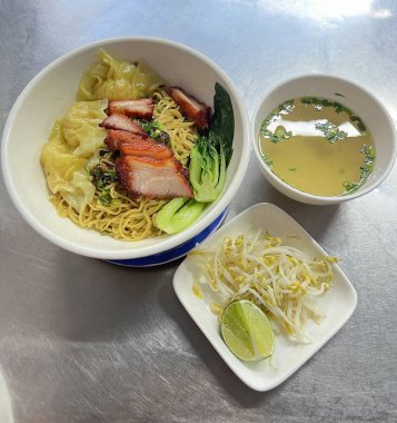 Kızarmış kırmızı domuz etli erişte ve domuz çorbasıyla servis edilen mantı.