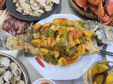 Ananas, domates ve soğanlı kızarmış balık.