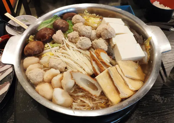 Japon güveç tenceresi et ve sebzelerle doludur.
