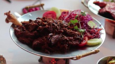 Yumuşak kuzu bacağı, romla marine edilmiş, egzotik otlar ve baharatlar, kömürde ızgara, Kuzey Hindistan mutfağı.