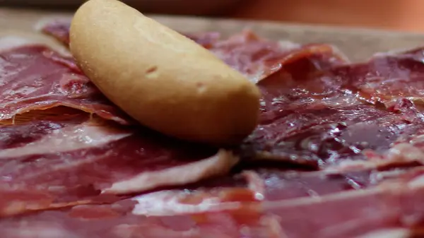 stock image A classic Spanish appetizer, Jamon Iberico served with a slice of crusty bread