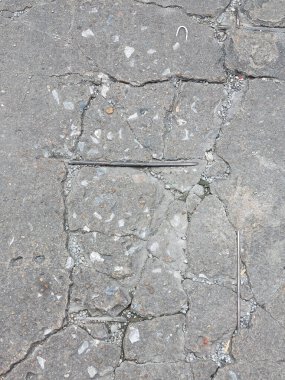 Hasar görmüş, kırılmış ve asfalt zemin çökmüş.