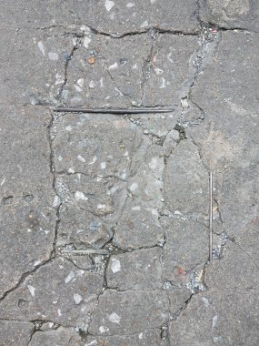 Hasar görmüş, kırılmış ve asfalt zemin çökmüş.