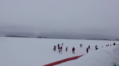 Turistler Laponya, Finlandiya 'daki Bothnian Denizi' nin buzlu sularında yürüdüler.