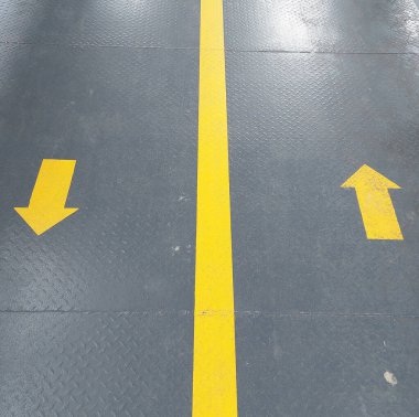 Üstgeçidin zemininde sarı yön işareti var.