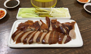 Hong Kong usulü kızarmış ördek, salatalık ve salatalık turşusu ile servis edilir.