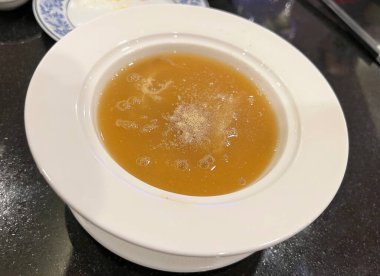 Kırmızı soslu haşlanmış köpekbalığı yüzgeci, üstüne biber dökülmüş.