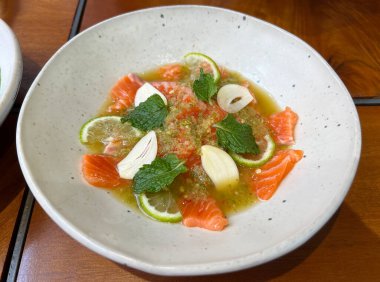 Ekşi ve baharatlı deniz ürünleri soslu somon balığı.