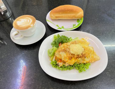 Sebzeli omlet, baget ve sıcak kahve. Kamboçya 'da Phnom Penh' de bir restoranda servis ediliyor..