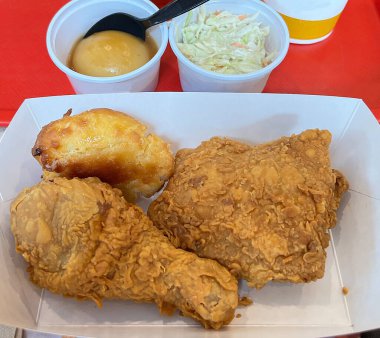 Kızarmış tavuk budu, kızarmış tavuk göğsü, bisküvi, fırında patates ve lahana salatası.