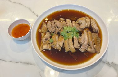 Braised duck, sliced and topped with broth, served with spicy dipping sauce clipart