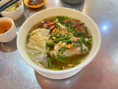 Kızarmış sarımsak ve taze soğanla kaplı domuz eti çorbası ve kızarmış kırmızı domuz eti..