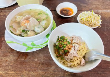 Kıymalı erişte, domuz eti çorbası, domuz pastırması ve karides ile servis edilir..