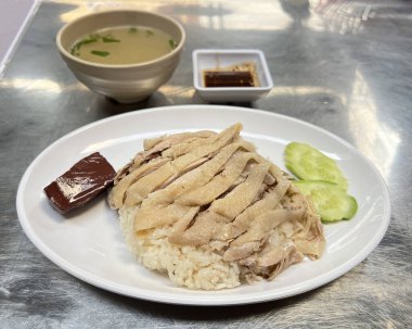 Tavuk budu ve kabuklu Hainanese tavuğu, çorba ve sos ile servis edilir..