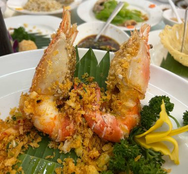 Çin yemek masasında servis edilen bol yağda kızartılmış sarımsaklı nehir karidesleri..