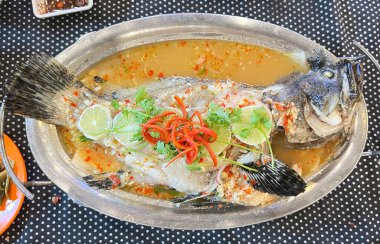 Limonlu buğulanmış levrek, paslanmaz çelik bir tabakta servis edilir..