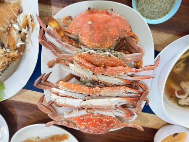 Buharda pişirilmiş mavi yengeç, bir deniz ürünleri restoranında masada servis edilir. 