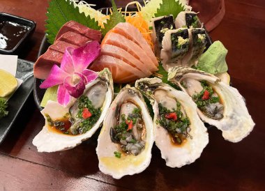 Sashimi seti somon, ton balığı ve marine edilmiş uskumru, Japon soslu taze istiridye ile servis edilir..