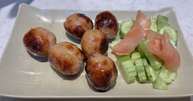 Salatalık ve turşulu zencefilli Isan usulü sosisler.