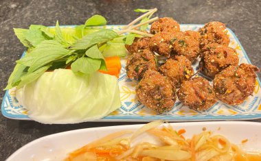 Kızarmış domuz eti, taze sebzelerle servis edilir.