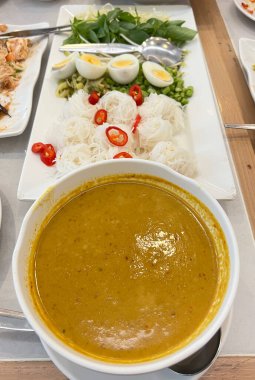 Köri soslu Tayland pilavı, çeşitli sebzeler ve haşlanmış yumurta ile servis edilir.