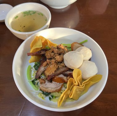 Kuru erişte, kırmızı domuz eti, balık köftesi ve kızarmış domuz köftesi.