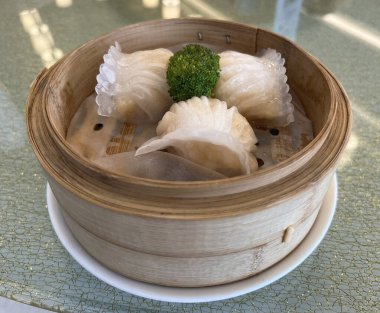 Bambu buharlı sepetinde servis edilen karides dolu har gow.