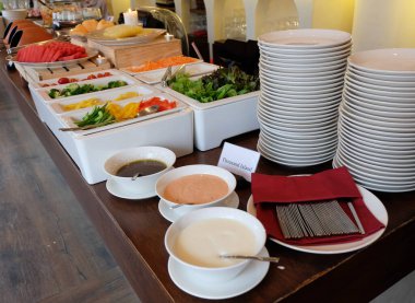 Taze sebze, meyve, salata sosu ve açık büfe konukları için tabaklar.