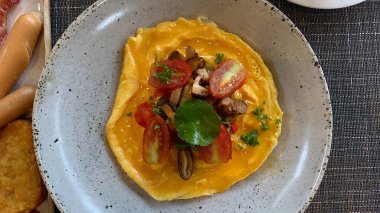 Şitake mantarlı ve domatesli çırpılmış yumurta.