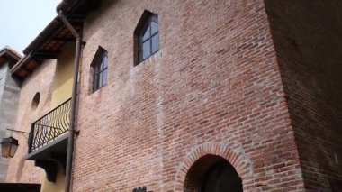 Avrupa tarzı eski bir binanın tuğla duvarında pencereler, bir çatı ve bir fener bulunur.