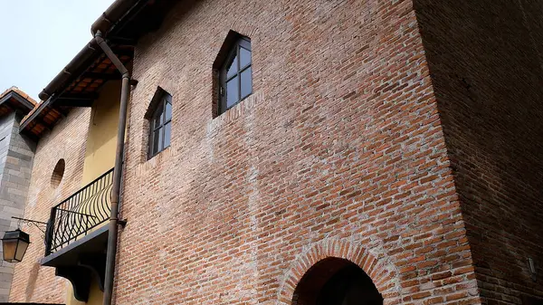 Avrupa tarzı eski bir binanın tuğla duvarında pencereler, bir çatı ve bir fener bulunur.