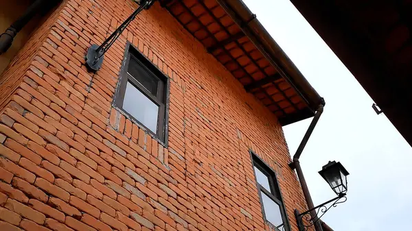 Avrupa tarzı eski bir binanın tuğla duvarında pencereler, bir çatı ve bir fener bulunur.