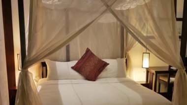 Bir otel odasında antika bir dört direkli yatak.