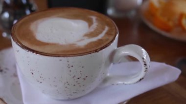 Kapuçino dolu seramik bir kahve fincanı.