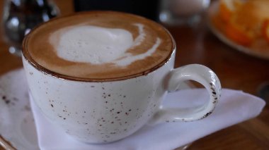 Kapuçino dolu seramik bir kahve fincanı.