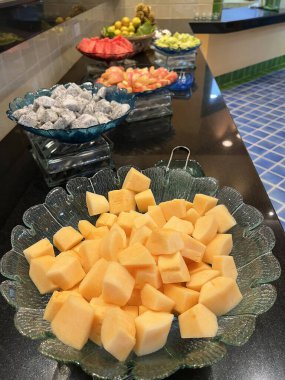 Açık büfe masasındaki bir tabakta rengarenk bir tropikal meyve seçimi.