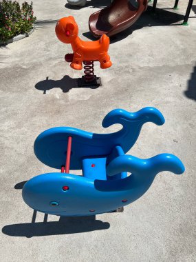 Çocuk parkında kedi ve balina şeklinde bahar süvarileri.