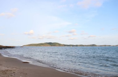 Yeşilliklerle kaplı bir ada manzaralı Rayong plajı.