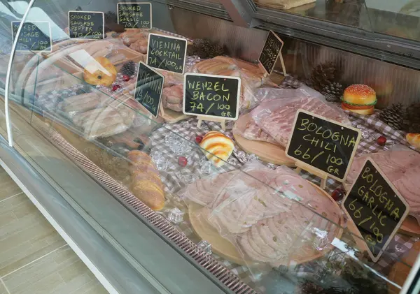 Çeşitli sosislerle dolu cam bir buzdolabı.