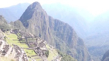 Arka planında cadı şapkası şeklinde bir dağ olan Machu Picchu.
