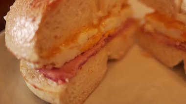 Yumurtalı, pastırmalı ve mayonezli çedar biberli simit, Luang Prabang 'da bir pastanede servis ediliyor.