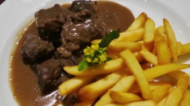 Biber soslu biftek küpleri, patates kızartmasıyla servis ediliyor.