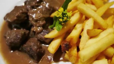 Biber soslu biftek küpleri, patates kızartmasıyla servis ediliyor.