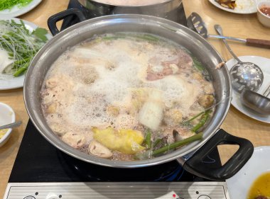 Elektrikli ocakta köpüren Sukiyaki güveç.