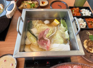 Bir Japon restoranında elektrikli ocağın üzerine yerleştirilmiş bir Shabu-Shabu kabı.