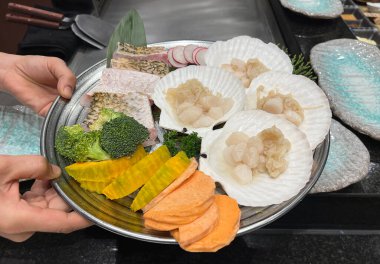 Bir tepsi deniz ürünü ve taze sebzeler pişirmek için hazırlandı.