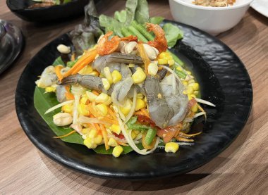 Tatlı mısırla karıştırılmış baharatlı Tayland papayası salatası ve taze karides.