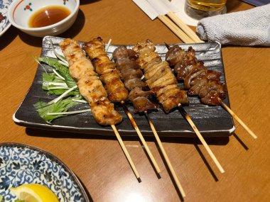 Yemek masasında Japon usulü ızgara şiş.